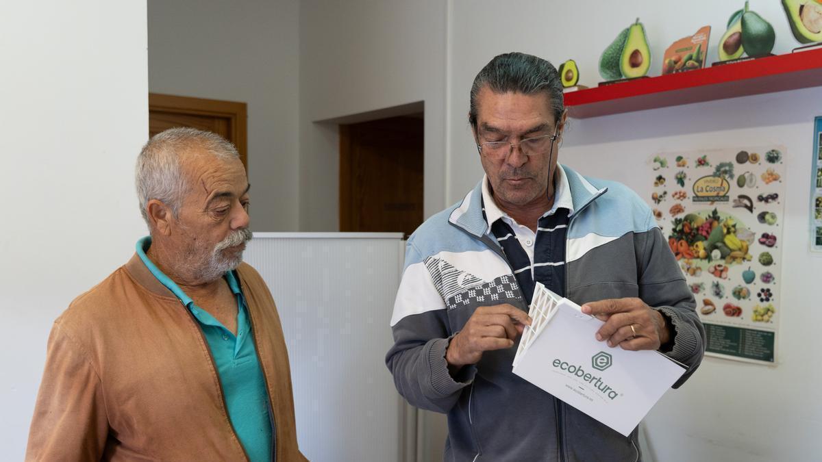 Por la derecha, el técnico de la Concejalía de Agricultura, Antonio Bello, muestra una trampa a un agricultor durante el reparto.