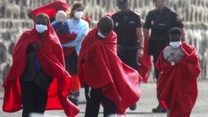 Jóvenes migrantes son recogidos por Cruz Roja y la Policía tras ser rescatados en la costa de Lanzarote.