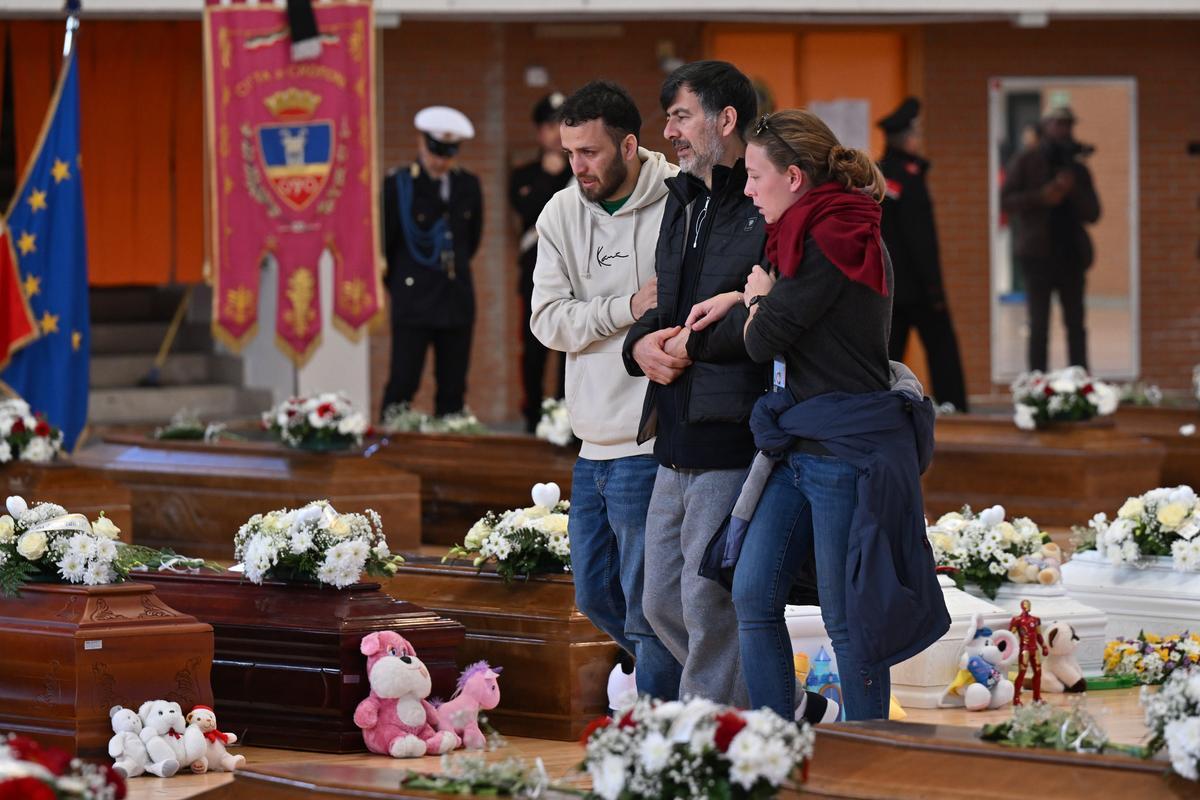 Familiares junto a los ataúdes de las 65 víctimas de un devastador naufragio de inmigrantes frente a la costa sur de Italia