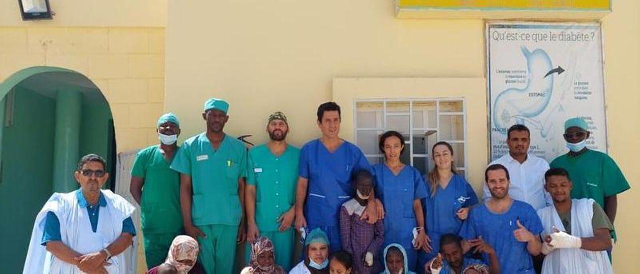 El doctor Javier Fernández Palacios, cuarto por la izquierda en la fila superior, junto al equipo médico y algunos de sus pacientes en una de sus visitas con África Plástica a Mauritania.