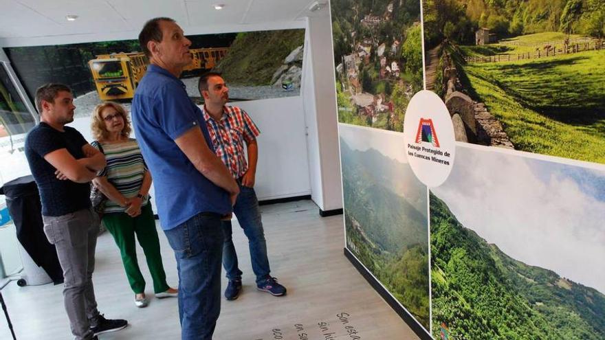 Por la izquierda, Elías López, Inés García, Jesús Sánchez y Manuel Ángel Álvarez observan el mural del paisaje protegido instalado en el pabellón de Langreo.