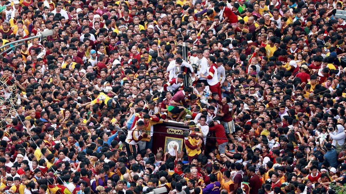 Devotos católicos se empujan para tocar la estatua del Nazareno Negro en su fiesta en Manila, Filipinas