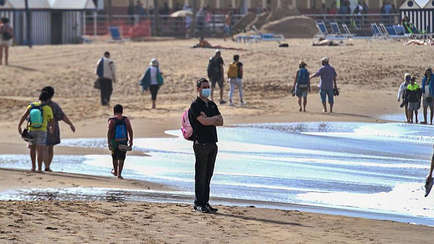 Varias personas pasean por la playa de Las Canteras el día de Navidad.