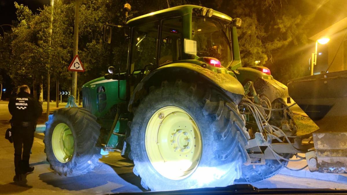 Un agente, al lado del tractor hallado en Espinardo.