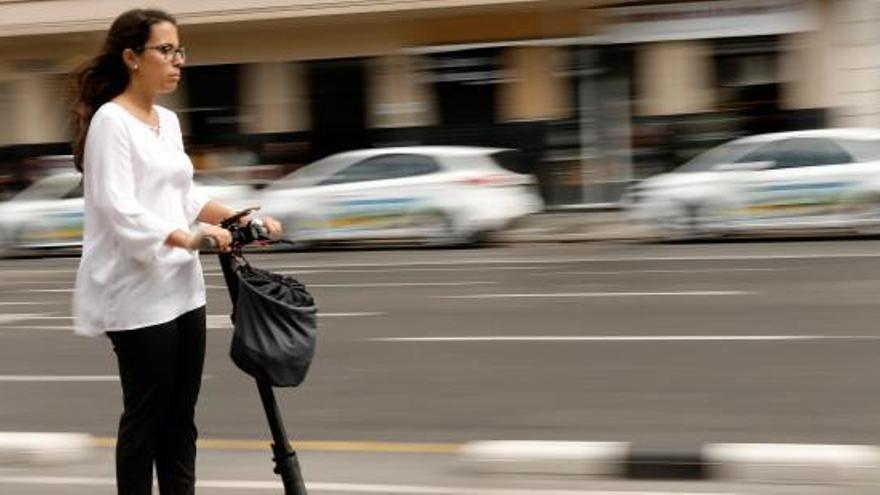 Una dona circula amb un patinet.