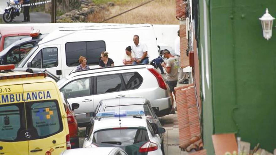 Familiares y vecinos delante de la vivienda donde se hallaron los cadáveres de la pareja y sus dos hijas.