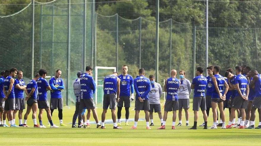 Los futbolistas del Deportivo, reunidos con el cuerpo técnico ayer sobre el césped de Abegondo. Rcd