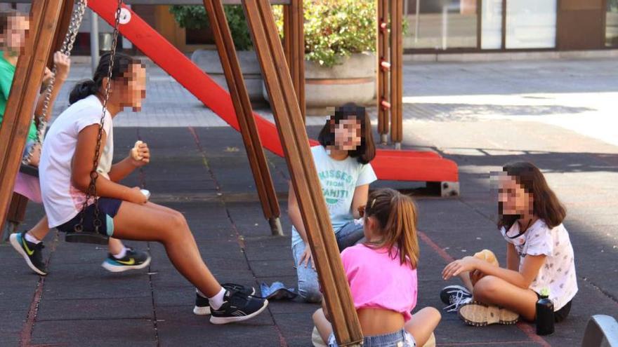 Un grup d&#039;alumnes de l&#039;escola Eiximenis de Girona jugant i esmorzant en uns gronxadors de la plaça Josep Pla