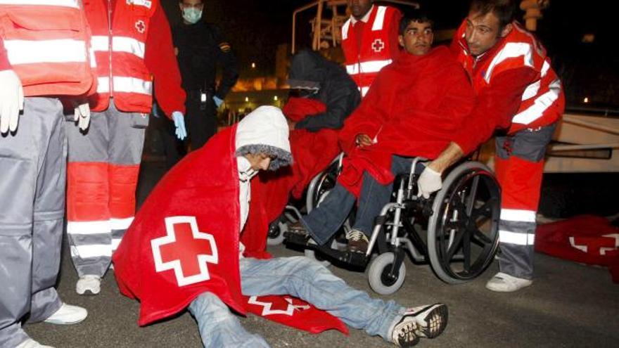 Efectivos de Cruz Roja socorren a varios inmigrantes que viajaban en una de las pateras que Salvamento Marítimo ha rescatado hoy cerca de la costa de Almería, tras ser trasladados al puerto almeriense.