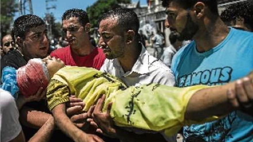 Diverses persones transporten el cadàver del nen de 10 anys mort ahir en un bombardeig israelià