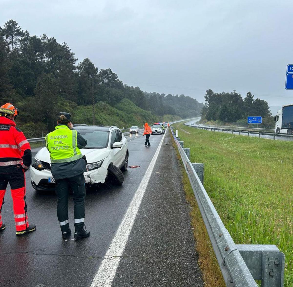 Un agente de la Guardia Civil de Tráfico con uno de los turismos siniestros en la A-52. |   // FDV