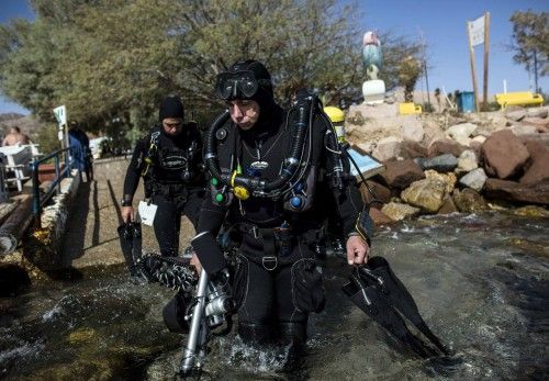 Un fotógrafo y una modelo trabajan bajo el agua en una sesión fotográfica de moda