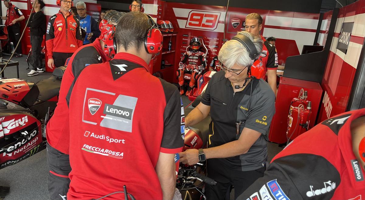 Los mecánicos de Marc Márquez preparan su Ducati mientras el campeón espera pacientemente en  su boxe de Jerez.