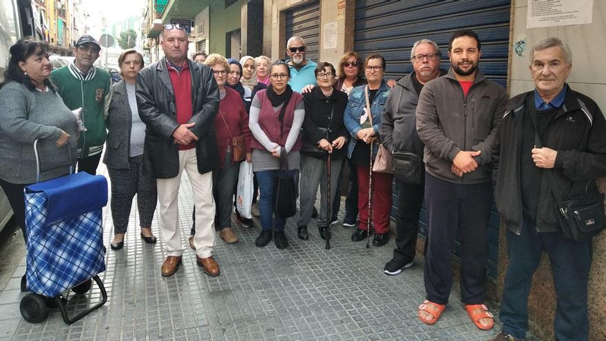 Grupo de usuarios delante del economato municipal que gestiona Amfremar, ayer, con el presidente vecinal Rafael Caparrós.