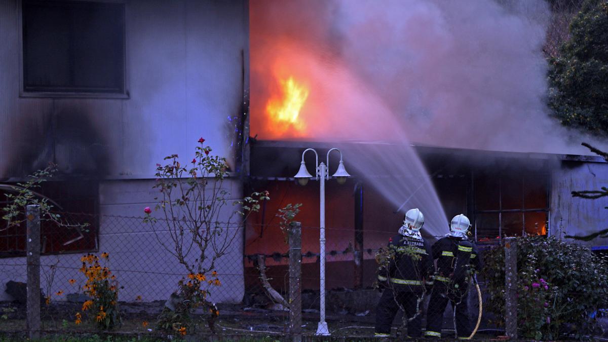 Los bomberos, en la extinción de un fuego en un taller y una casa de Porto Berres, en A Estrada, en 2019.