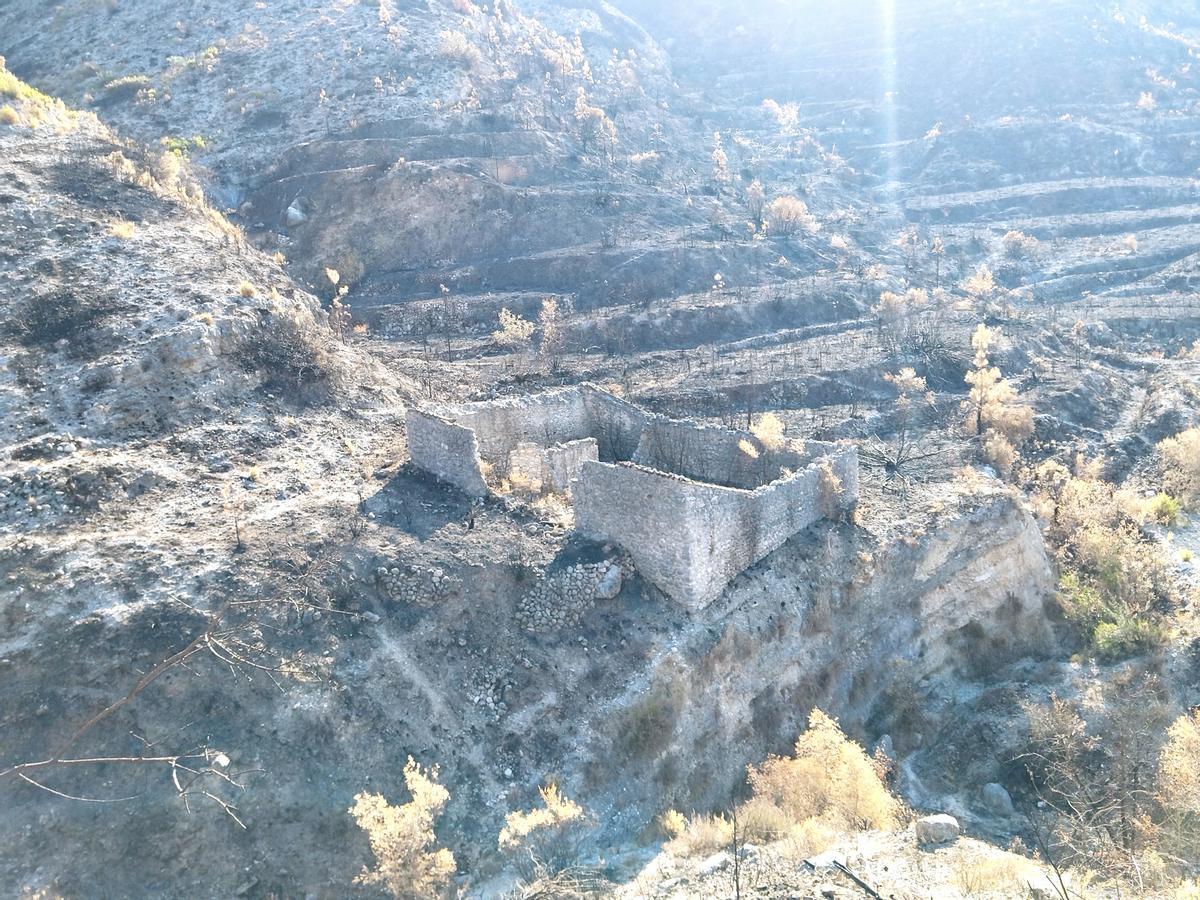 Construcción abandonada en una ladera calcinada y donde se adivinan las antiguas terrazas de cultivo