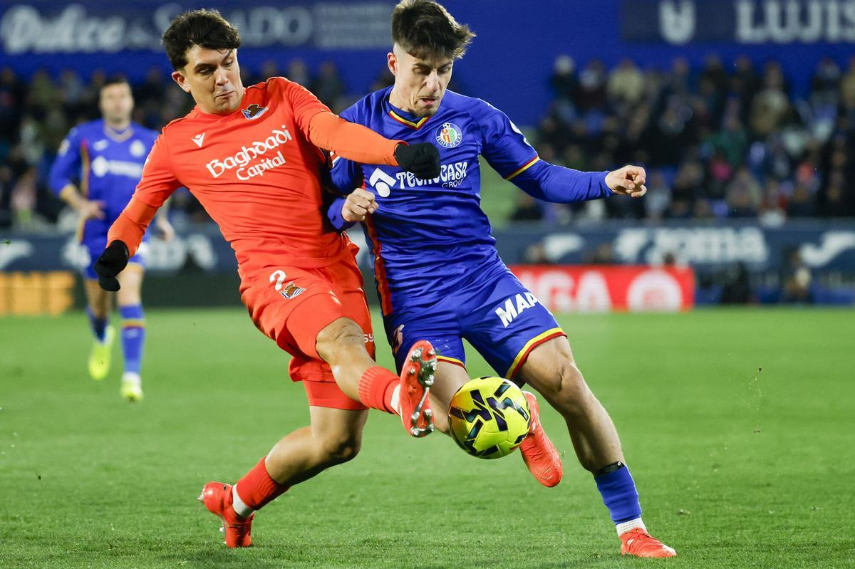 GETAFE (COMUNIDAD DE MADRID), 09/01/2026.- El delantero del Getafe Adrián Liso (d) pelea un balón ante el defensa de la Real Sociedad Jon Aramburu durante el partido de la jornada 19 de LaLiga EA Sports que disputan Getafe CF y la Real Sociedad este viernes, en el Coliseum de Getafe (Comunidad de Madrid). EFE/ Juanjo Martín