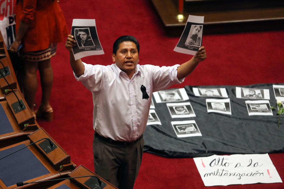 Miembros del Congreso sostienen pancartas mientras le gritan al primer ministro de Perú, Alberto Otarola, mientras él y su gabinete enfrentan un voto de confianza, en Lima (Perú).