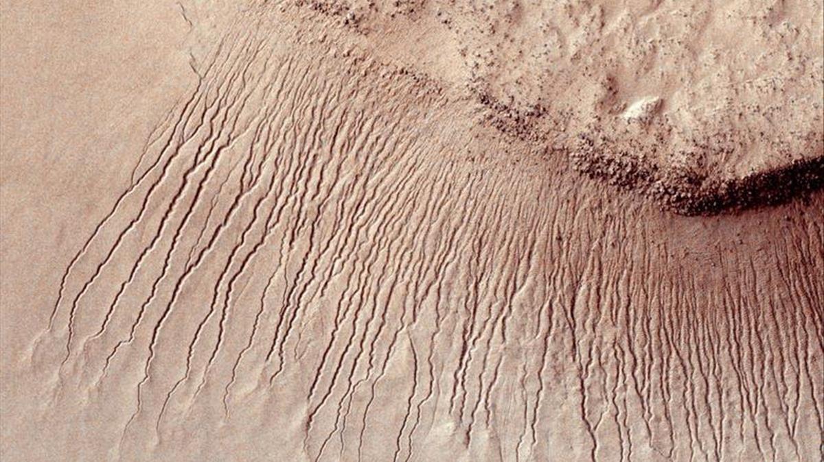 Partes de la superficie marciana que muestran muchos canales de uno a 10 metros de ancho en una escarpa en la cuenca de impacto de Hellas.