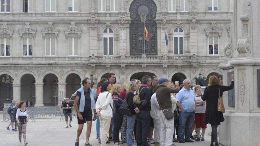 Un grupo de turistas en una excursión en la plaza de María Pita.