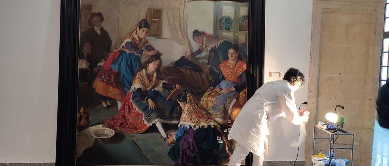 La restauradora Gloria García Pertejo trabaja en el cuadro «Vistiendo a la novia». | J. N.