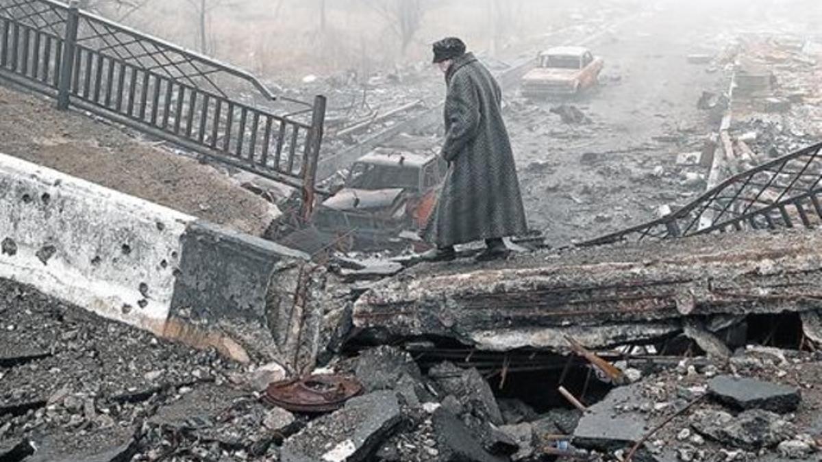 Una mujer camina sobre un puente destruido cerca del aeropuerto de Donetsk en una imagen de archivo.
