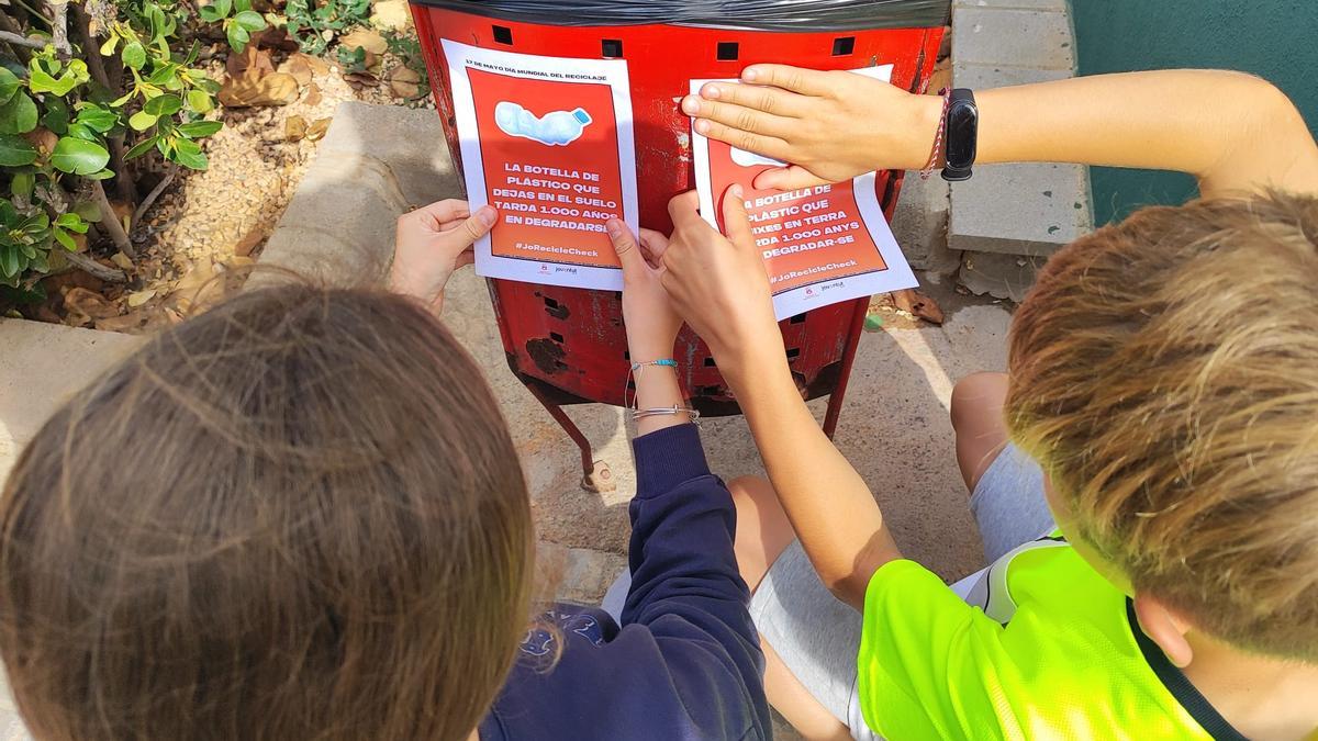 Unos niños, colocando carteles.