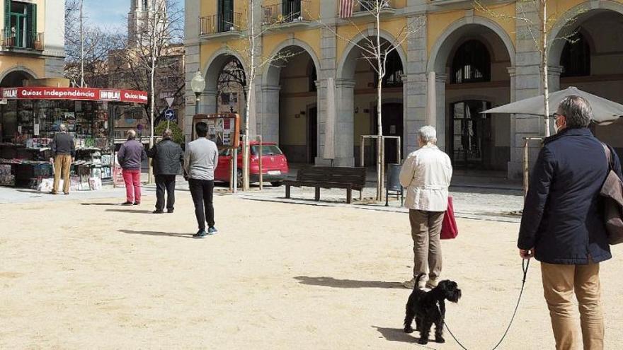 Cues per comprar el diari complint la distància de seguretat al centre de Girona