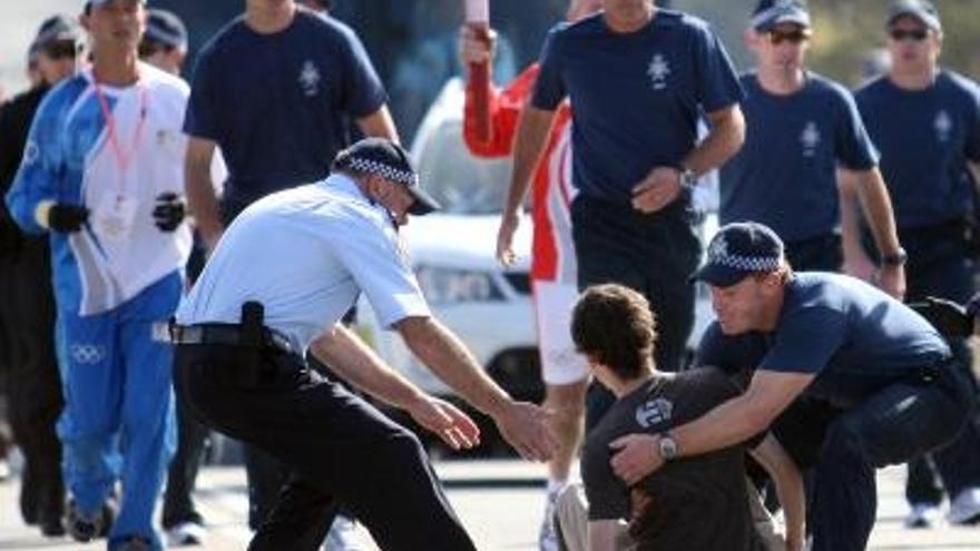 La Policía interviene para mover a un manifestante ante el paso de la llama olímpica en Canberra.