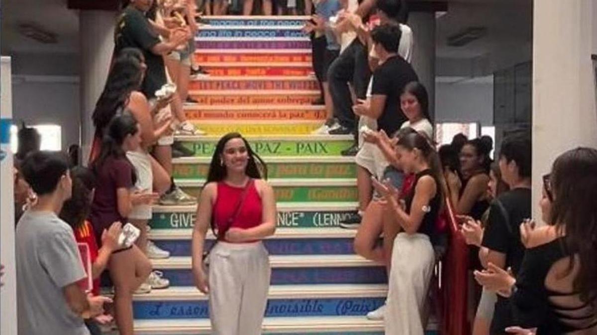 Leticia Fernández baja por las escaleras del IES Guadalpín, de Marbella, ovacionada por sus compañeros.