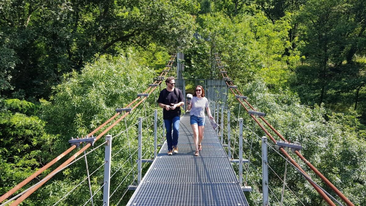 Una pareja cruza la pasarela metálica de o Xirimbao, que une Teo con A Estrada sobre el Ulla