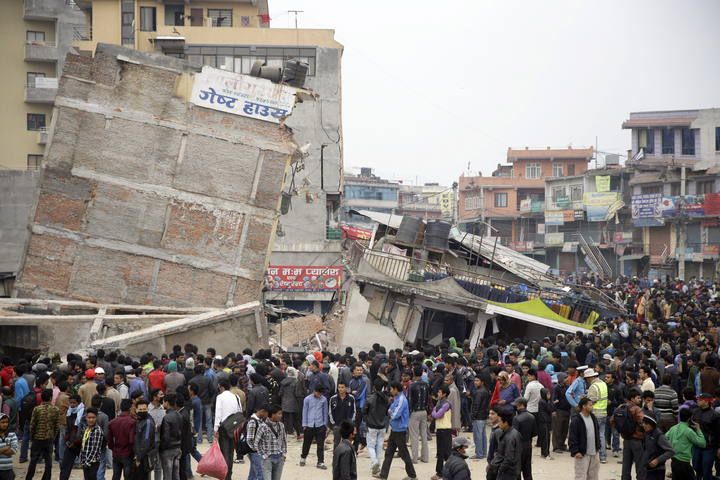 Nepalíes se reunen junto a los edificios dañados a la mañana siguiente del terremoto