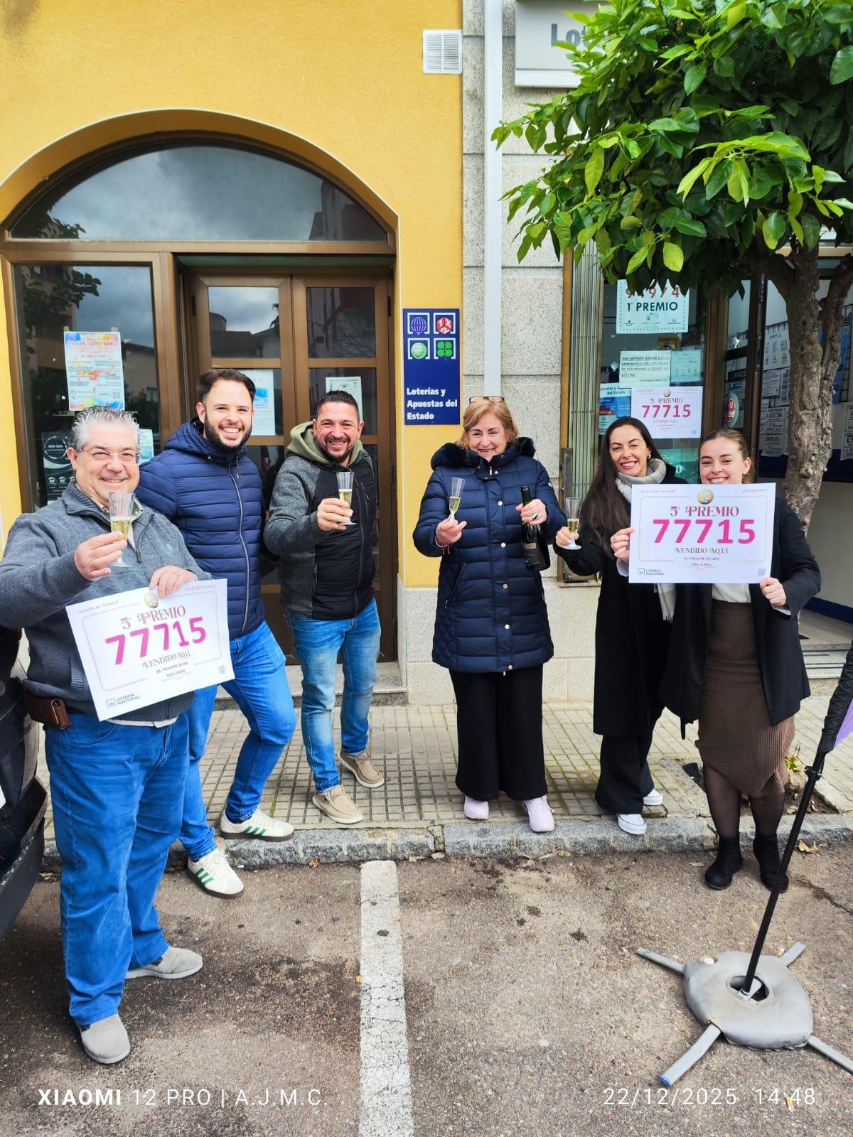 Antonio Jesús Masa, propietario de la administración El Tomate de Oro, y su hija Laura Masa, que también trabaja en el establecimiento, posan con los carteles del número premiado junto a amigos y familiares.