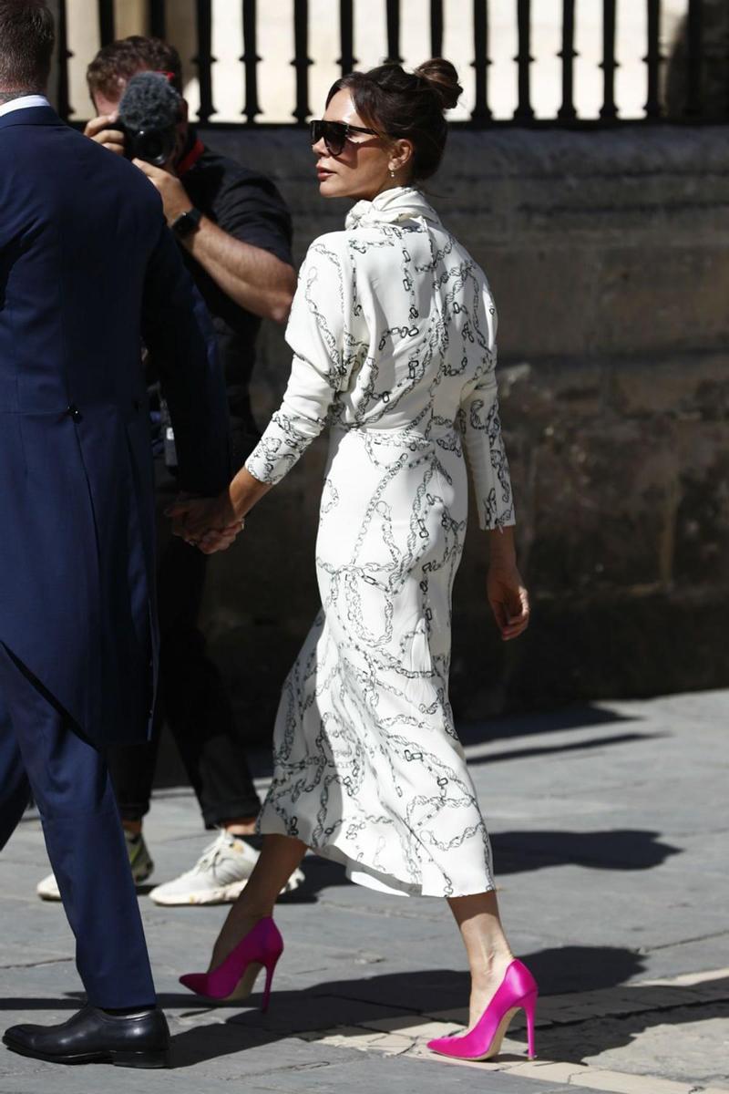Victoria Beckham con vestido blanco y zapatos fucsia