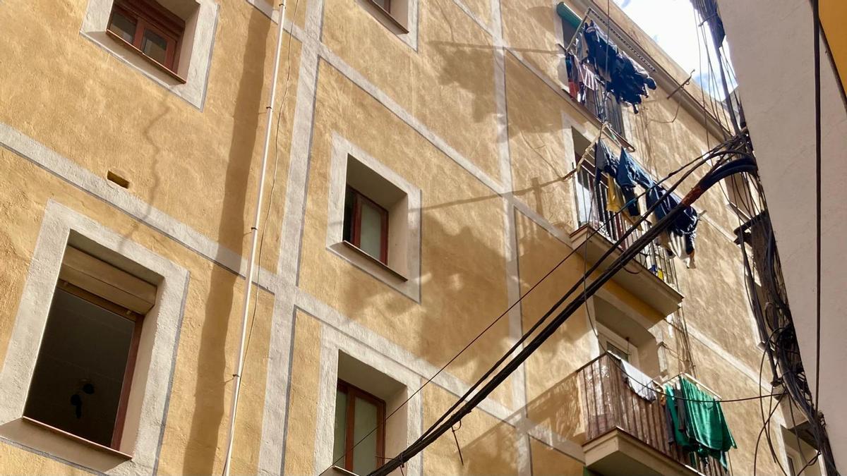 Fachada de un edificio de la calle de Carretes, en el Raval, donde se vende un piso okupado de 46 m2 por 60.765 euros.