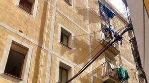 Fachada de un edificio de la calle de Carretes, en el Raval, donde se vende un piso okupado de 46 m2 por 60.765 euros.