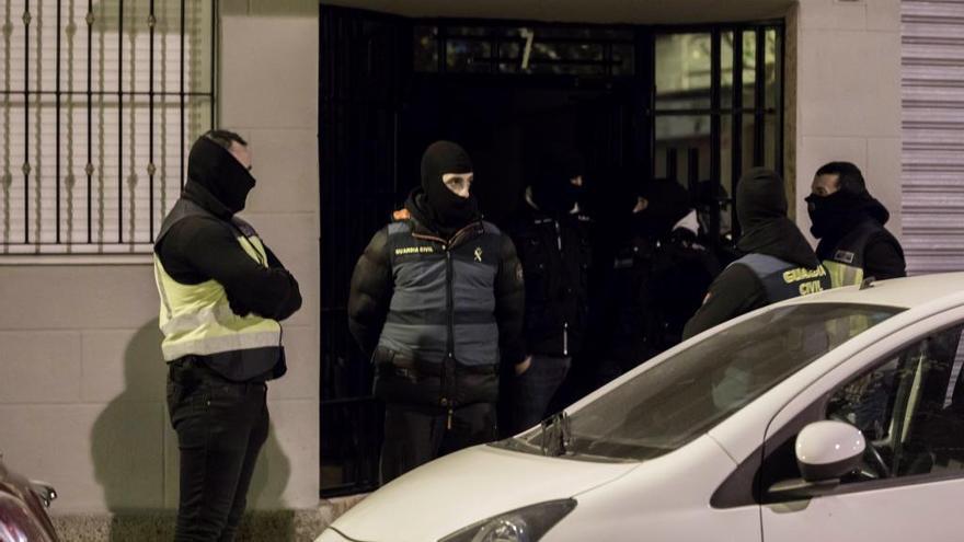 Agentes de la Policía y de la Guardia Civil, durante uno de los registros en Quart.