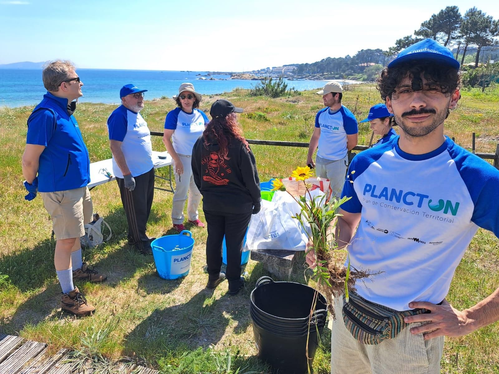 Participantes en la jornada de voluntariado que Abanca y Afundación llevan a cabo esta tarde en la playa grovense de Area da Cruz para eliminar basura marina y especies invasoras.
