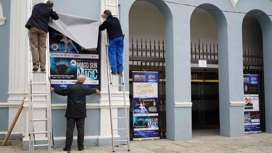 Los operarios colocan los carteles en la fachada del Ramos Carrión.