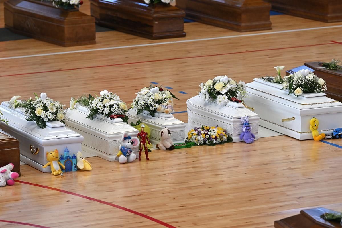 Familiares junto a los ataúdes de las 65 víctimas de un devastador naufragio de inmigrantes frente a la costa sur de Italia