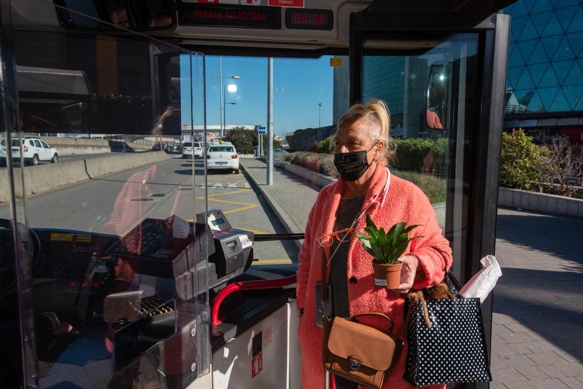 Una usuaria del bus sube al vehículo con mascarilla, esta mañana en Marineda City.