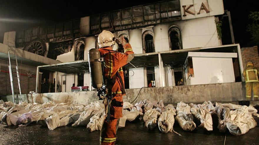 Un bomber fa una fotografia de la discoteca al costat de desenes de cadàvers de víctimes.