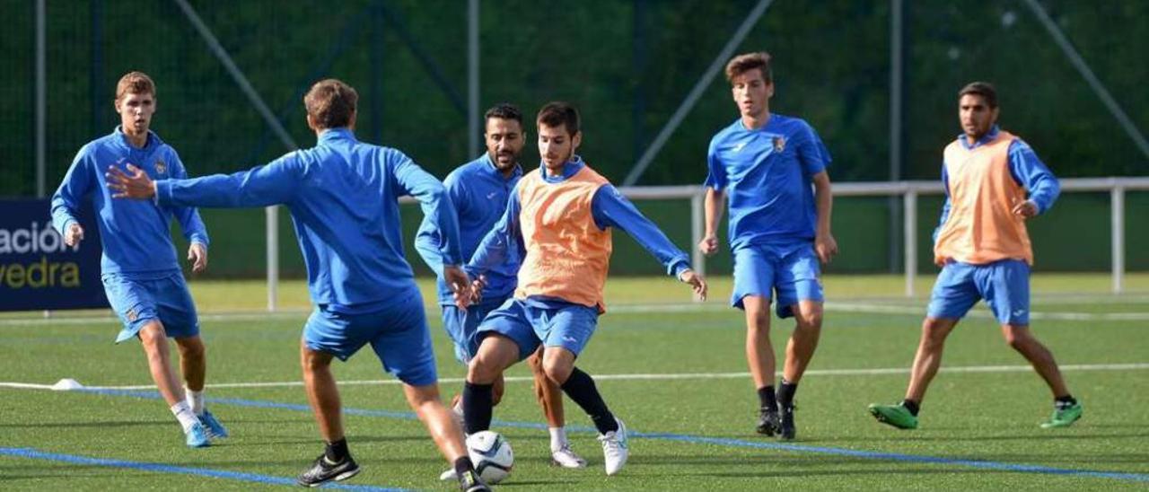 Jandrín conduce el balón ante la presión de sus compañeros durante un entrenamiento en Príncipe Felipe. // Gustavo Santos