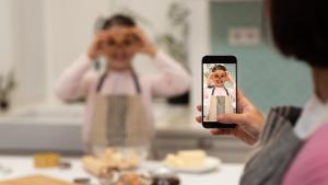 Una mamá influcencer graba a su hija mientras cocinan galletas y pasteles, en su casa.