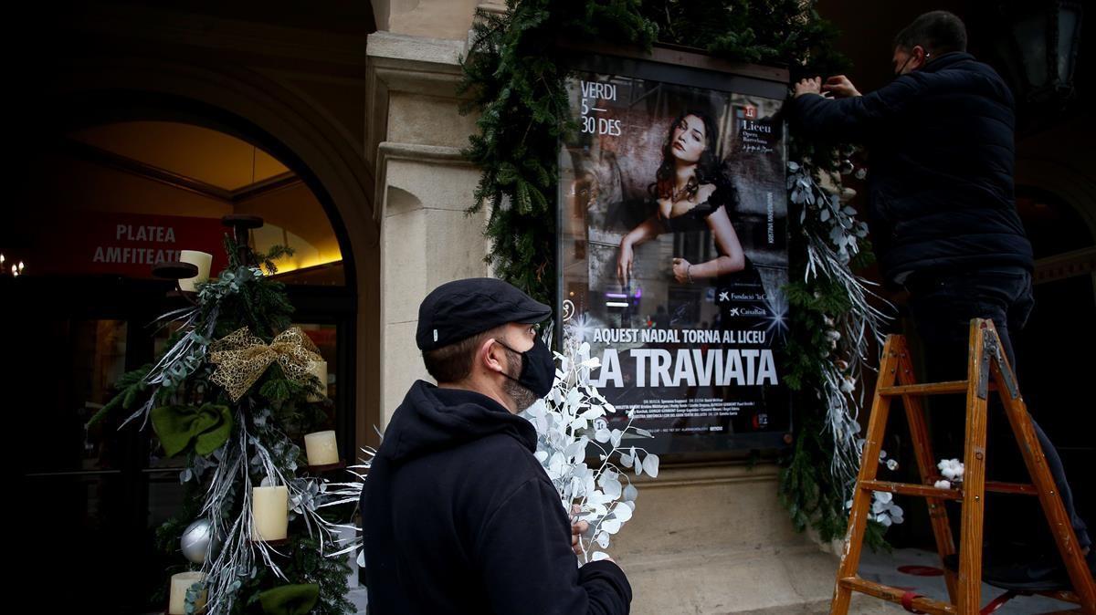 GRAFCAT5665  BARCELONA  07 12 2020 - Dos trabajadores decoran la fachada del Gran Teatre del Liceu  poco despues de anunciarse que suspendera las funciones de manana y del dia 9 de diciembre de  La Traviata  debido a que no podra aumentar su aforo hasta el 50 por ciento de la sala  tal y como reclama desde hace dias  pero esta a la espera de una  revision  del Procicat  EFE Quique Garcia