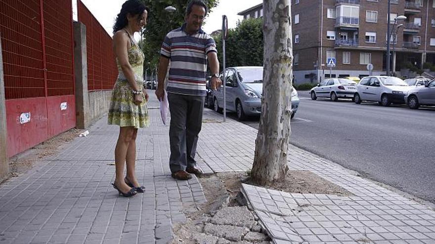 Francisco Guarido y Laura Rivera, concejales de IU, muestran los desperfectos de las aceras en la calle de Arapiles.