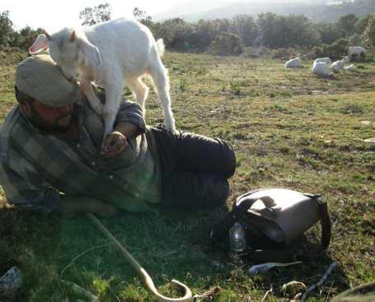 El pastor con una de sus ovejas durante un descanso.