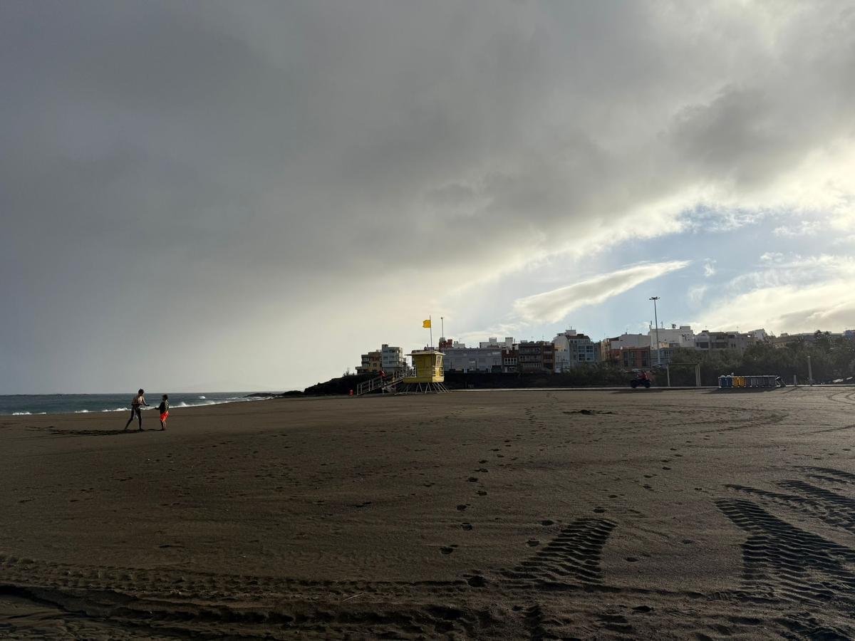 Dos menores juegan en la playa de Melenara tras la reapertura