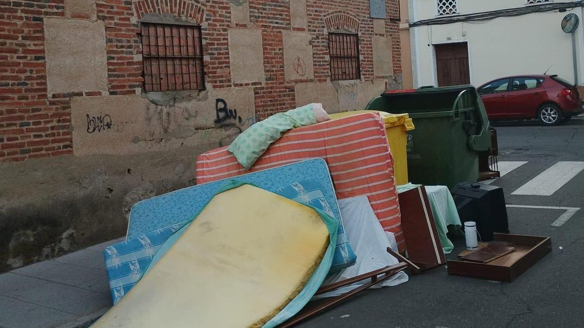 Colchones y otros enseres tirados en plena calle.