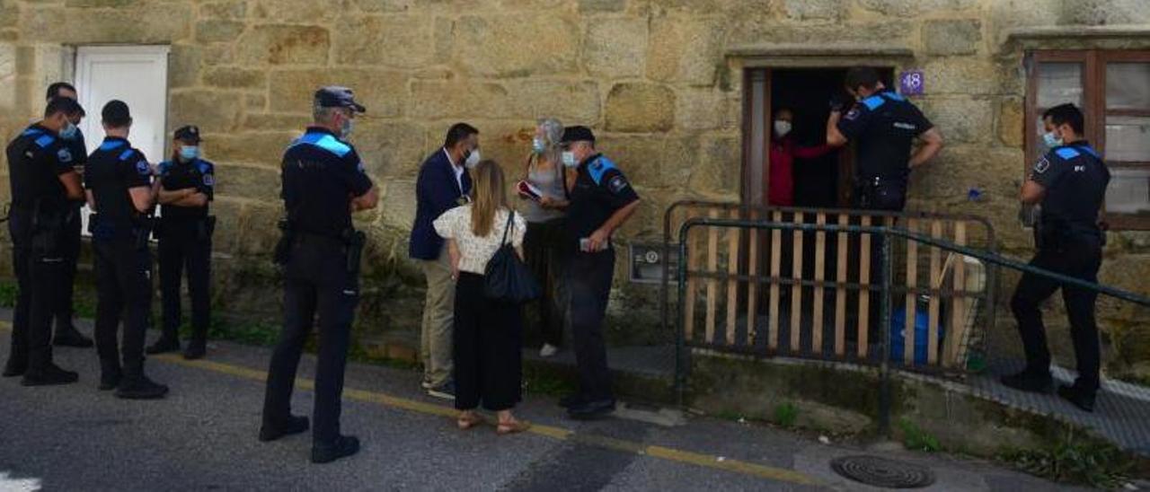 Una de las okupantes abre la puerta del número 48 de la calle Ensinanza tras ser requerida por la comisión judicial y la Policía Local.   | // G.NÚÑEZ